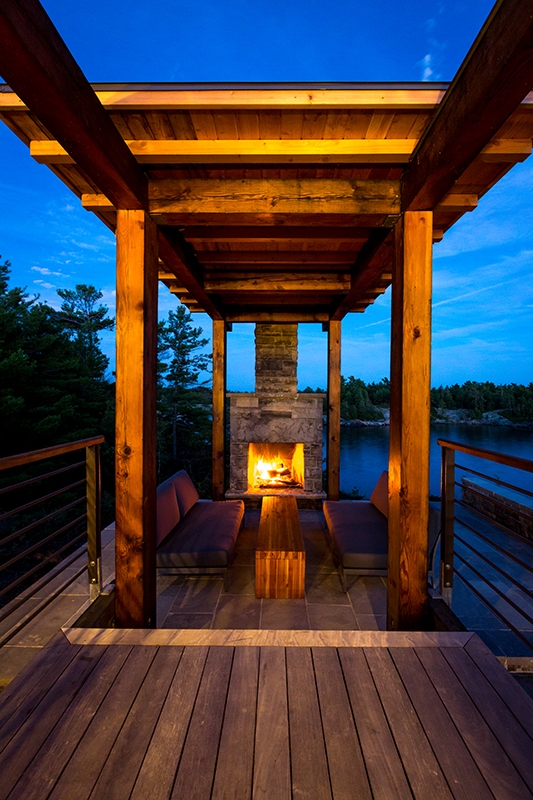 terrasse cheminée de nuit - Cottage Country par Core Architects - Baie géorgienne, Canada
